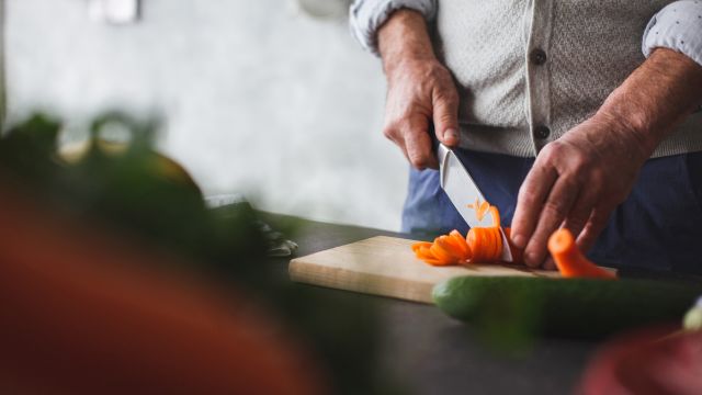 A man chops vegetables. A healthful diet is an important focus when living with leukemia.