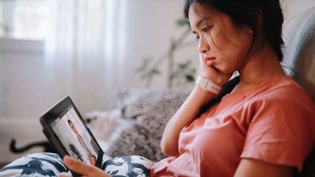 A young migraine patient speaks to her healthcare provider during a telehealth appointment.