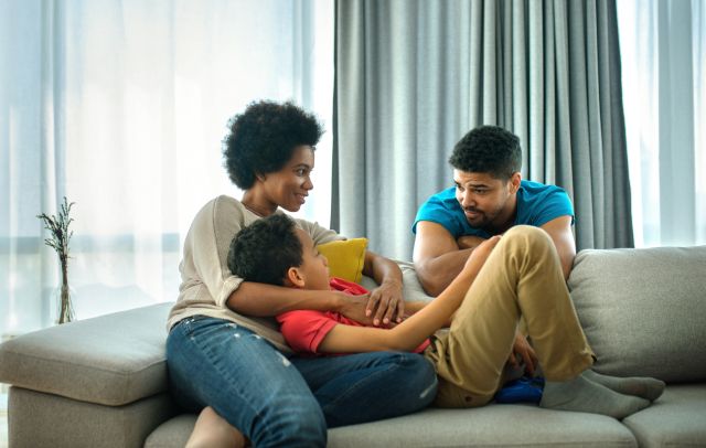 Parents and son relaxing on a sofa and talking