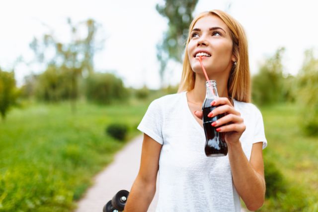 Girl drinking a soda from a glass bottle, summer mood