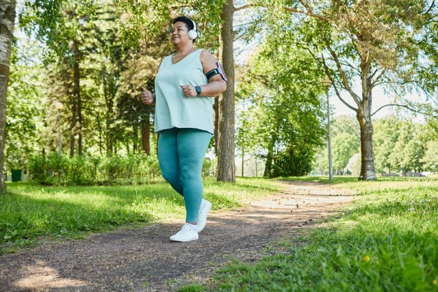 Full length portrait of senior black woman enjoying morning run in park