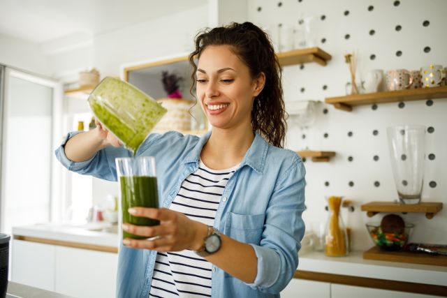 woman  in a kitchen pouring a smoothie packed with antioxidant rich foods to lower cancer risk
