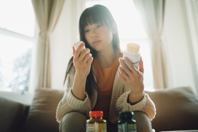 woman looking at vitamin bottles