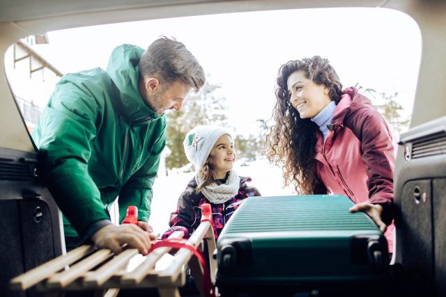 family packing car trunk for holiday road trip