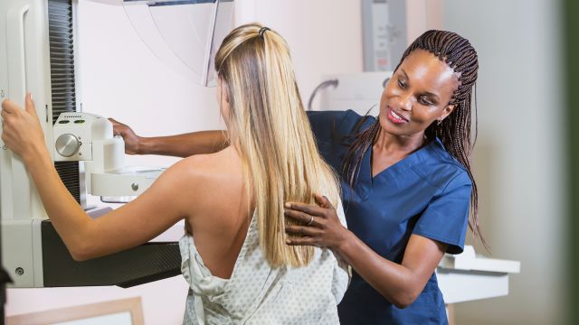 a nurse helping a patient through a mammogram