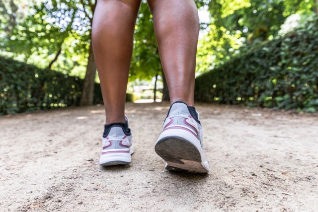 closeup of person in sneakers walking in park