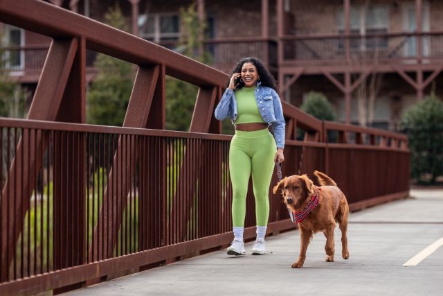 young woman and dog walk along bridge
