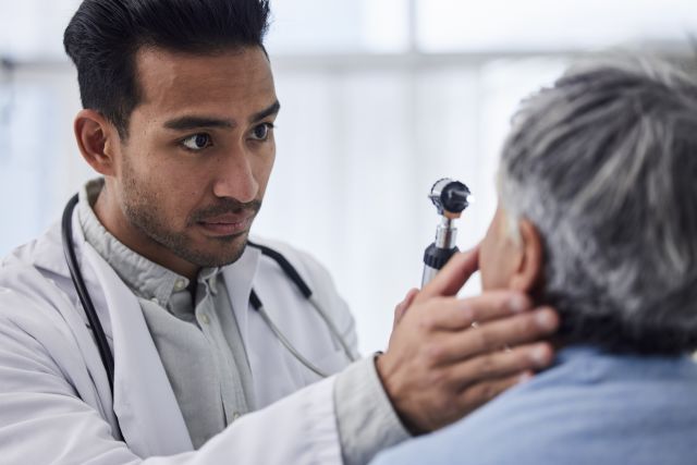eye doctor examines male patient
