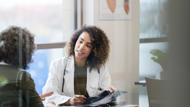 A middle-aged woman consults with a healthcare provider about the results of a bone density exam.