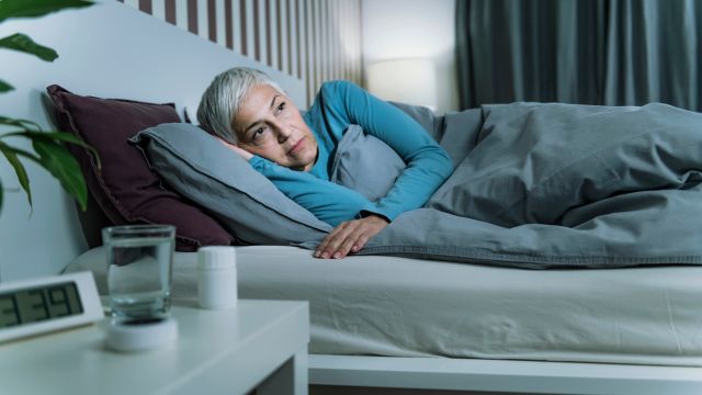 A senior woman struggles to sleep. Sleep disturbances are one of the most common non-movement symptoms of Parkinson's disease.