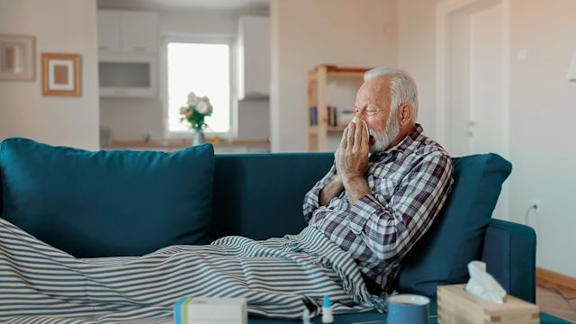 A senior man is home sick with the flu. Getting the annual flu shot can help reduce the severity of flu symptoms if a person does get sick.