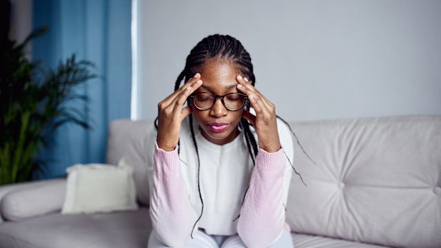 A young woman takes a moment during a stressful day. Psychological stress is often associated with atopic dermatitis flares and more severe atopic dermatitis symptoms. 