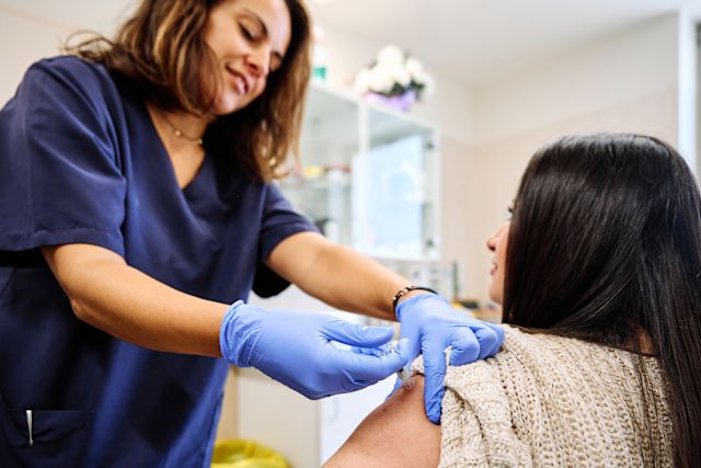 nurse giving woman vaccine