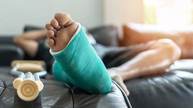 Man recovers from surgery while resting on couch.