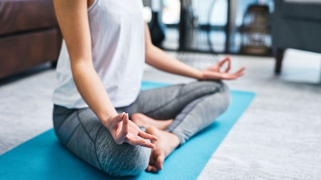 A woman meditates to help cope with the stress, anxiety, and uncertainty of living with ulcerative colitis.