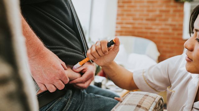 A healthcare provider injects a GLP-1 medication into the lower abdomen of a patient during an appointment to provide training for self-administration of injectable medications.