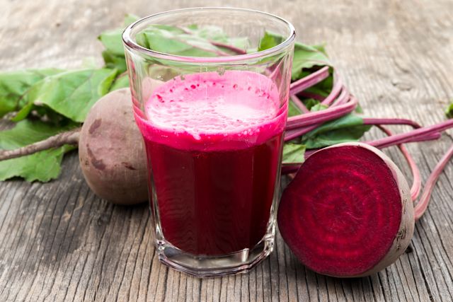beet juice and halved beets on wood