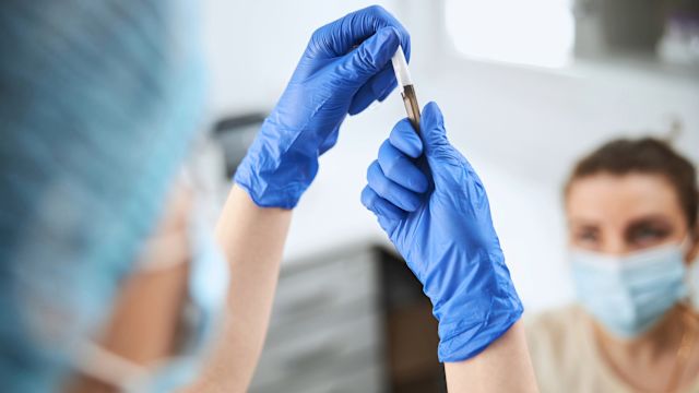 A nurse prepares a syringe to administer a dose of a complement inhibitor medication to a female patient with a complement-mediated kidney disease.