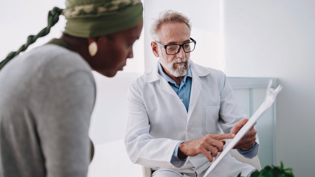 An oncologist outlines surgical options with a young female patient diagnosed with breast cancer during an appointment.