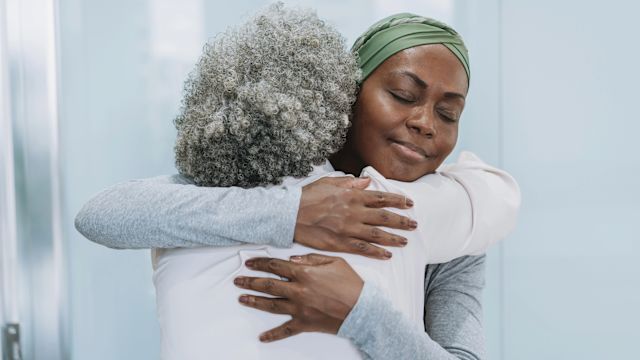 A woman with breast cancer hugs a friend before she goes in for surgery.