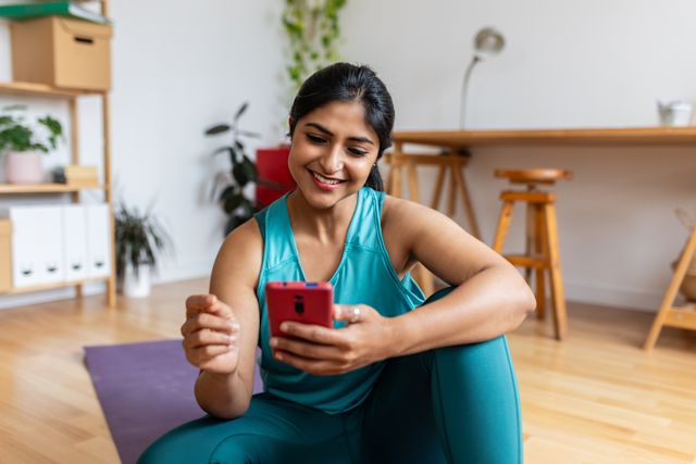 young woman tracking activity on her phone at home