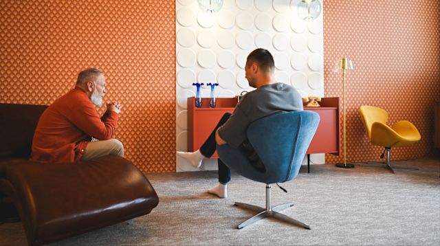A man talks to his therapist during an appointment in a modern-style office. Counseling and therapy are important aspects of treatment for opioid use disorder (OUD).