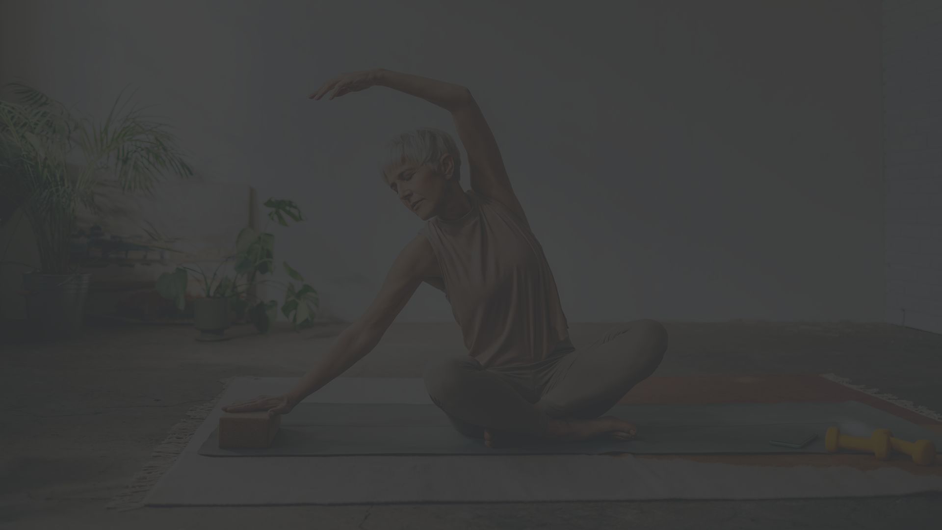 a middle aged white woman does a yoga pose on the floor to help improve flexibility and strengthen bones 