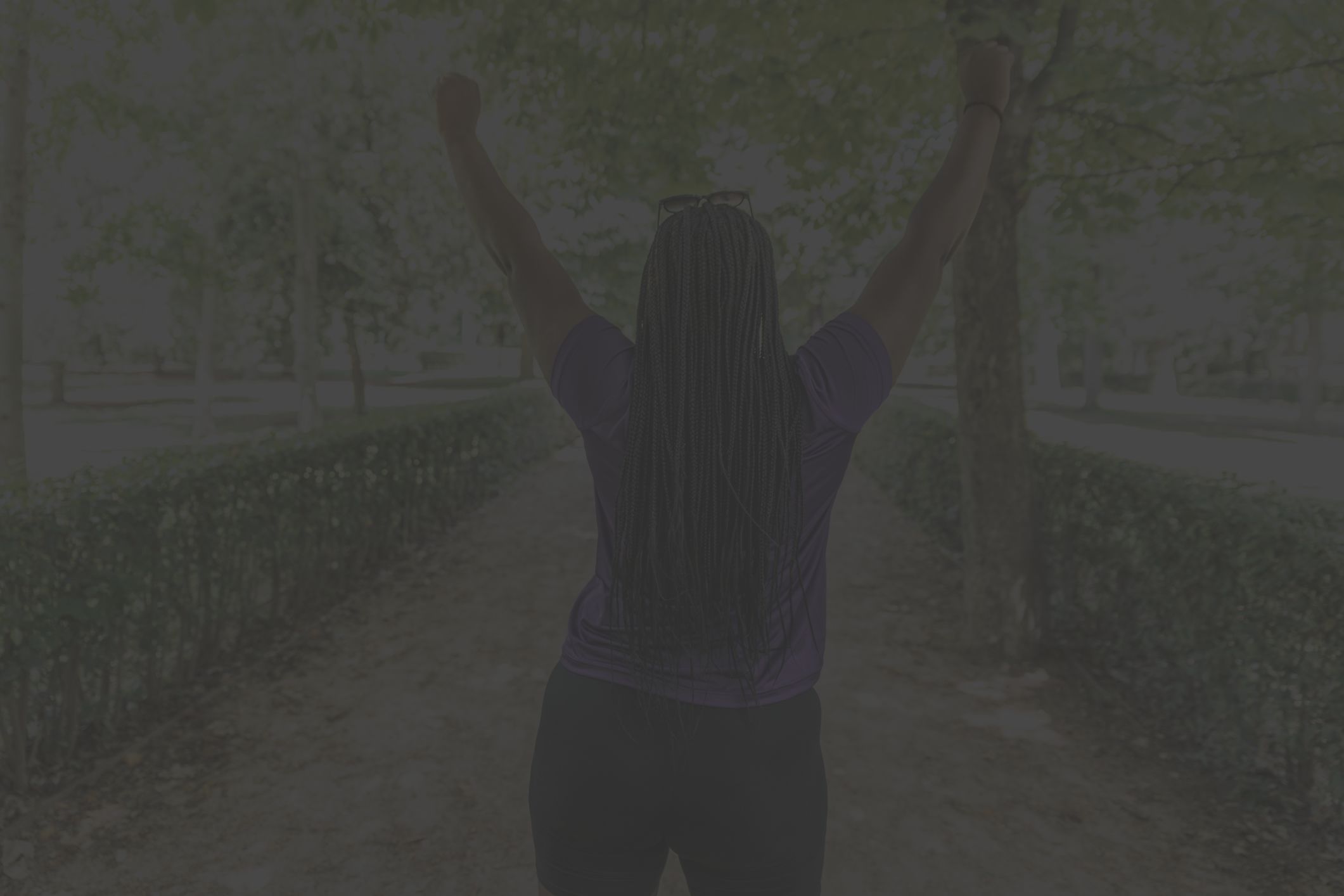 Someone standing and raising arms to make victory sign