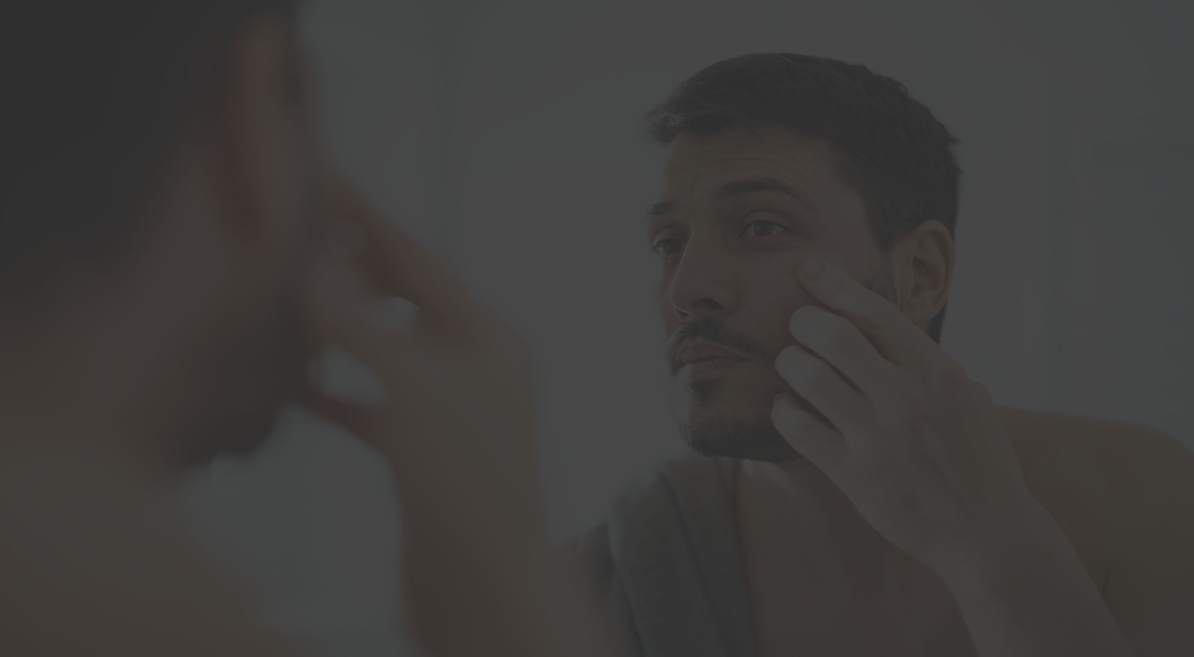 someone examining facial skin in bathroom mirror