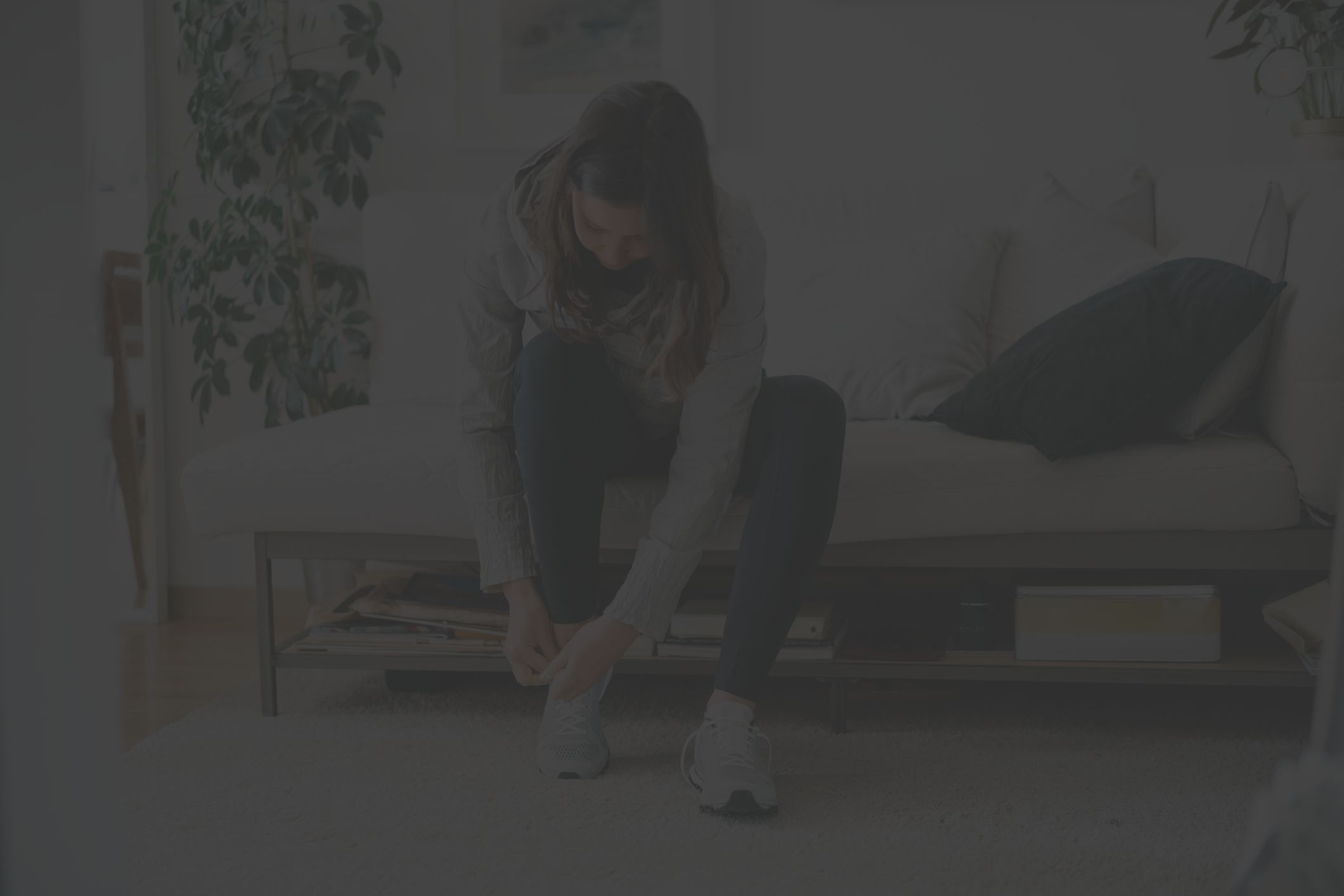 woman lacing up sneakers at home