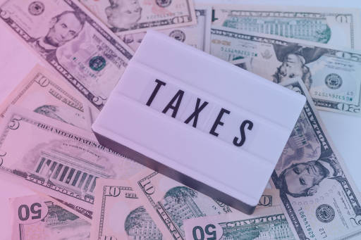 A "Taxes" sign on top of money.