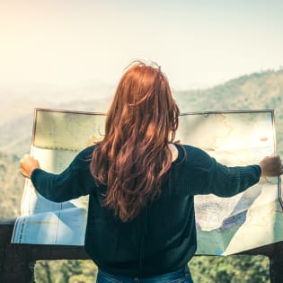 Woman in mountains looking at map